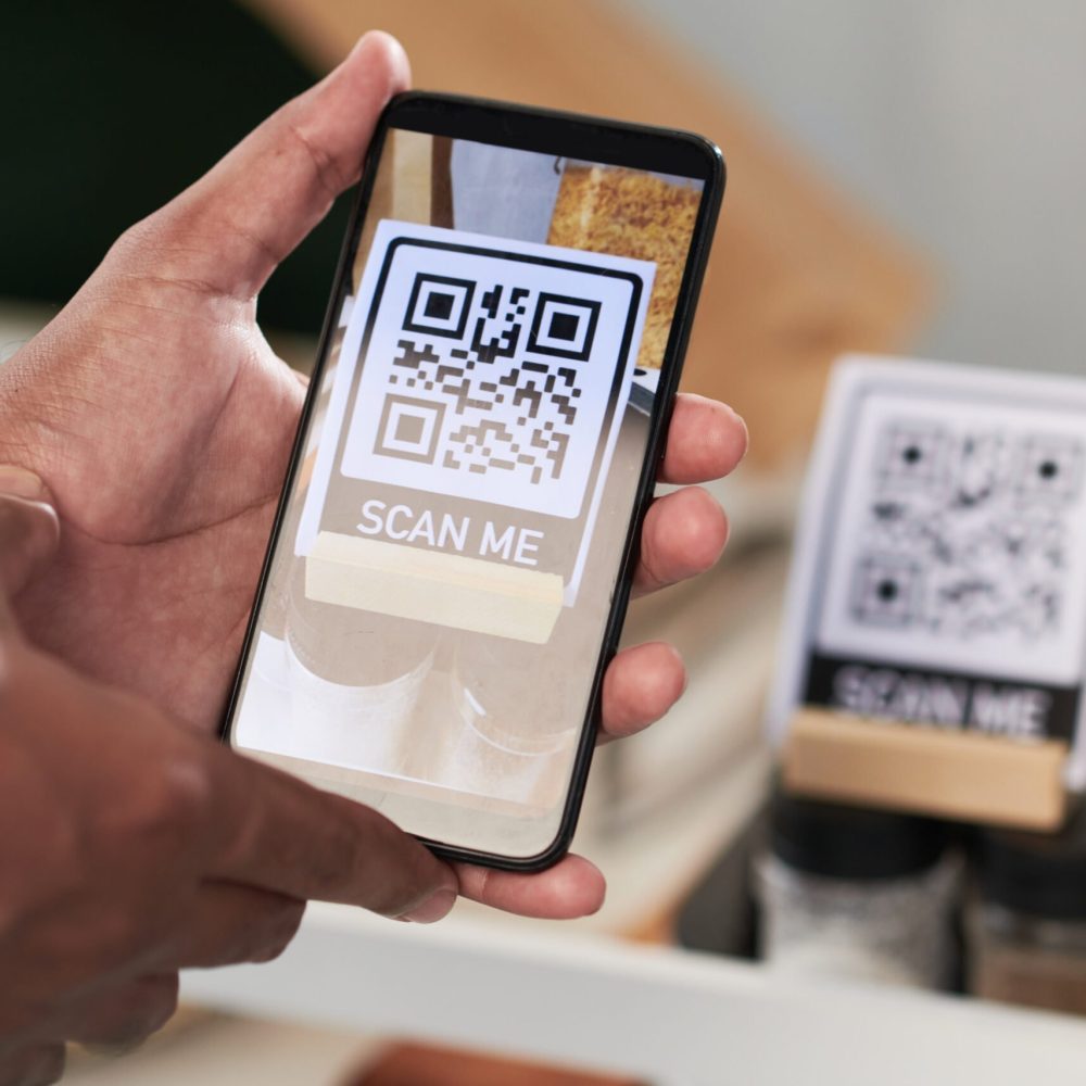 Close-up image of customer scanning QR code with smartphone to download cafe menu